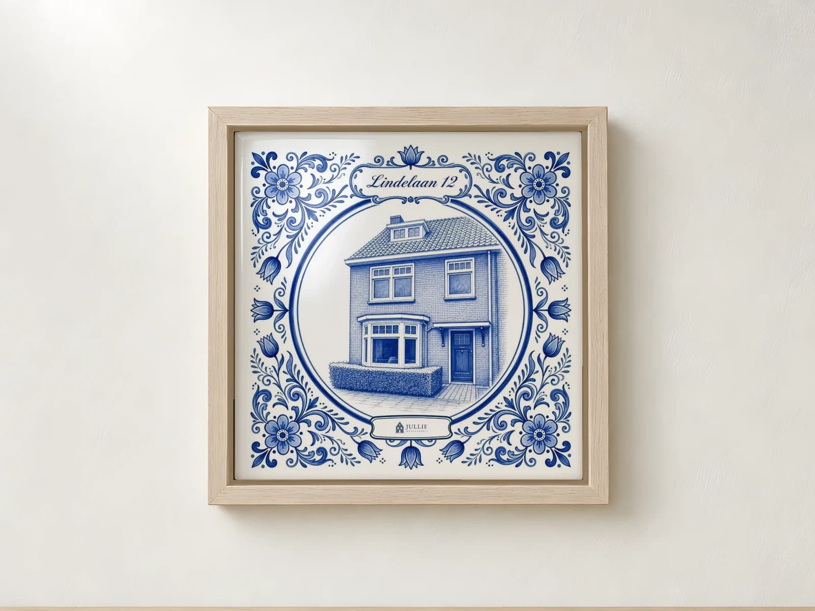 Delfts blauw tegeltje van een woning, verdiept in een houten lijst aan de muur