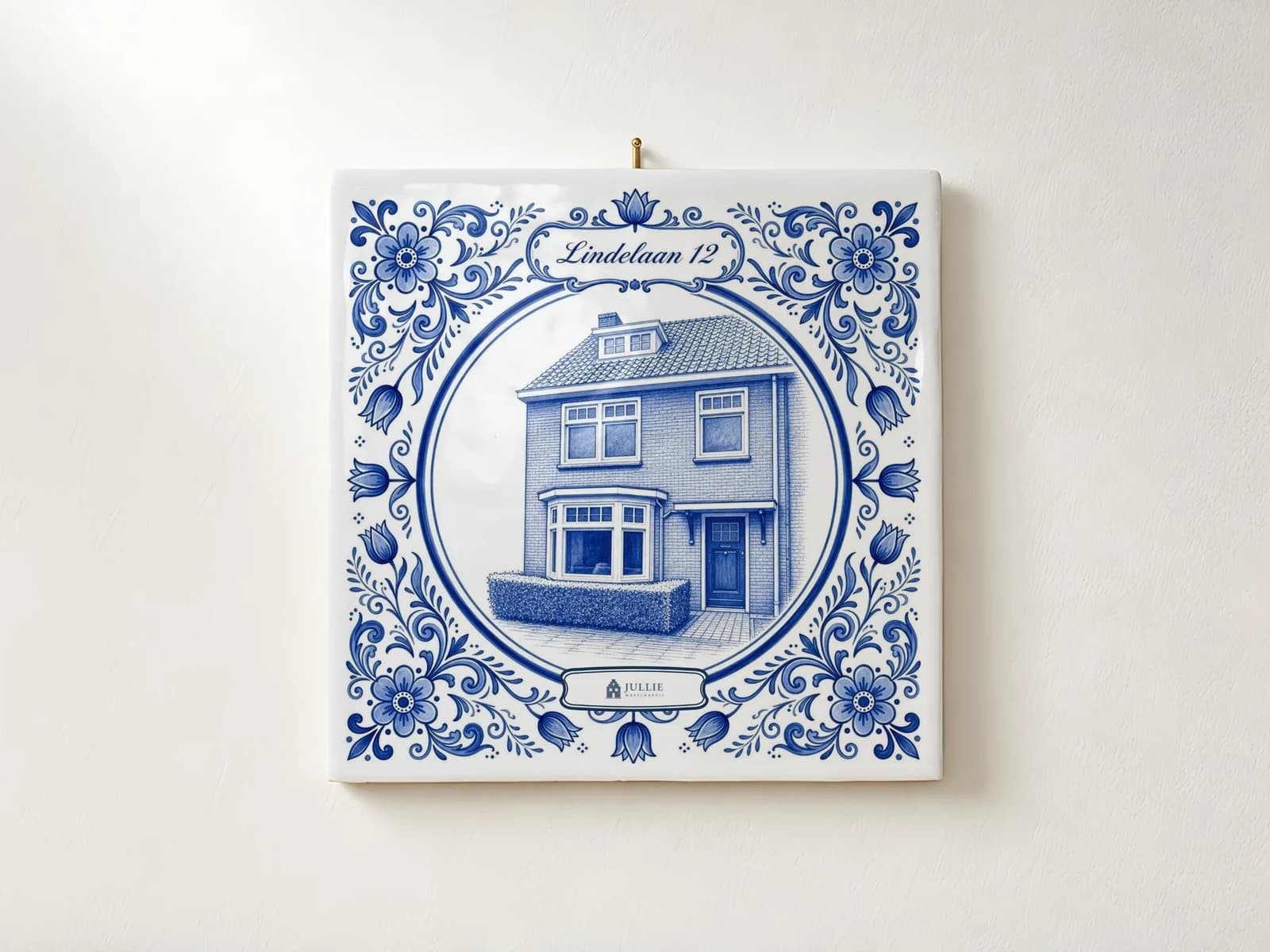 Delfts blauw tegeltje van een woning aan de muur