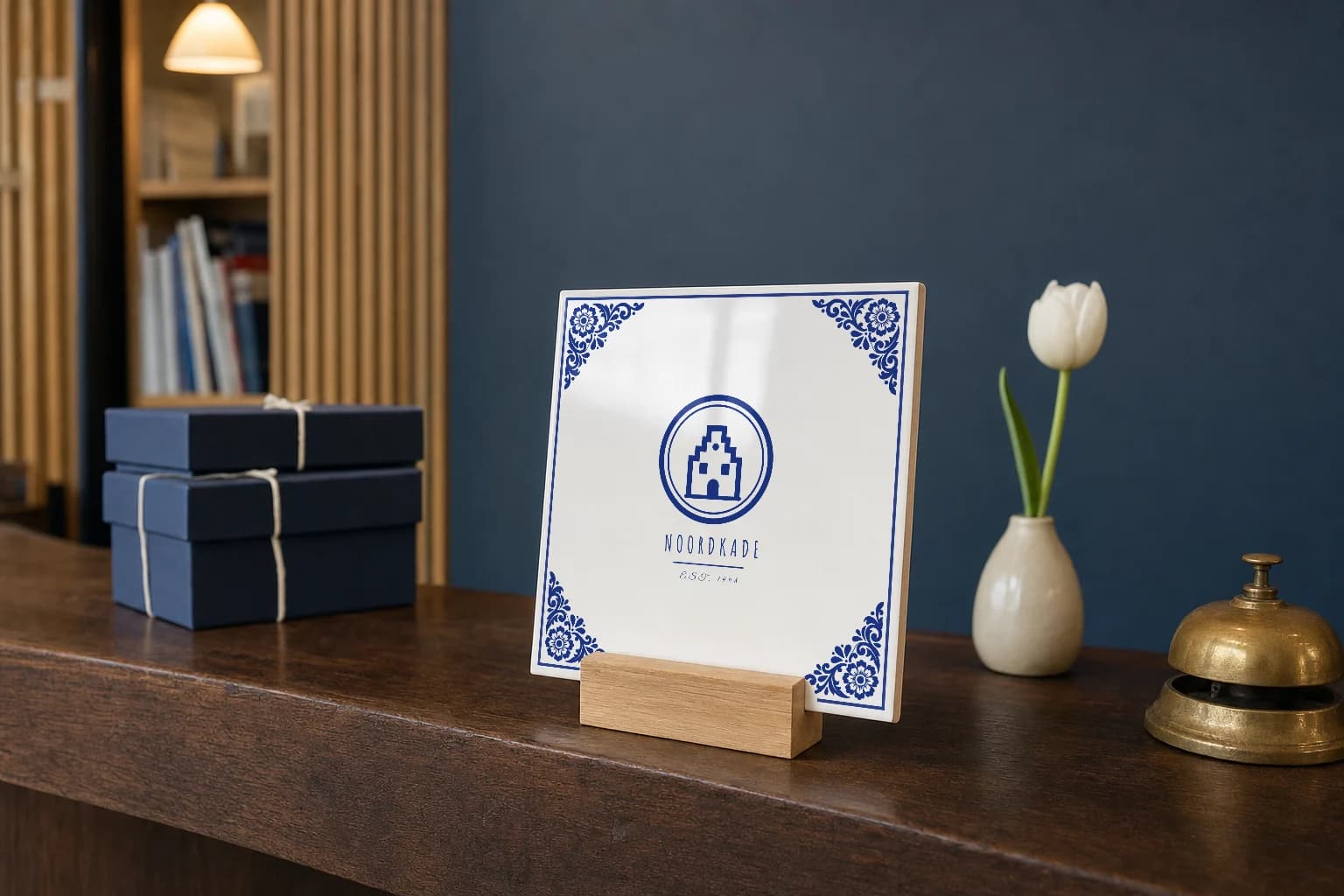 Delfts blauw logotegeltje in een eiken houder op de balie van een kantoor